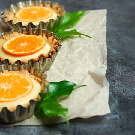 Hand made tart, tartlet with lemon curd on a black background. Selective focus, copy space...