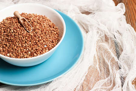 Buckwheat in a bowl on a wooden table. Selective focusの写真素材