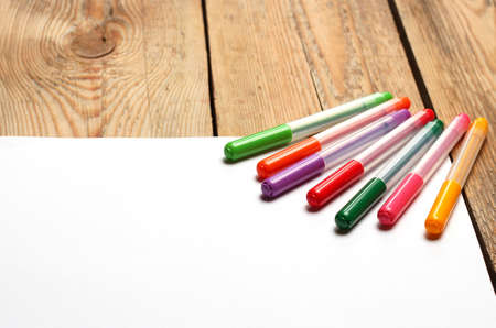 Still life, education concept. Felt tip pens on a paper on a wooden table. Selective focus, copy...