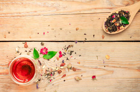 Still life, healthcare, food and drink concept. Herbal tea in a spoon and a glass on a wooden table. Selective focus, copy space background, top viewの写真素材
