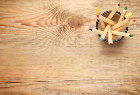 Still life, business, education concept. Pencils in a mug on a wooden table. Selective focus, copy space background, top viewの写真素材