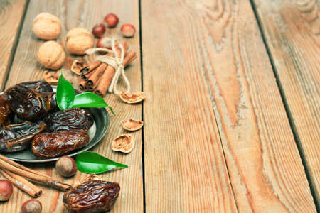 Still life, food and drink, holidays concept. Ramadan dates and spices on a wooden table. Selective focus, copy space backgroundの写真素材