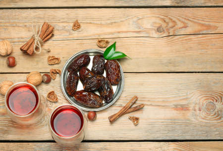 Still life, food and drink, holidays concept. Ramadan dates and tea on a wooden table. Selective focus, copy space background, top viewの写真素材