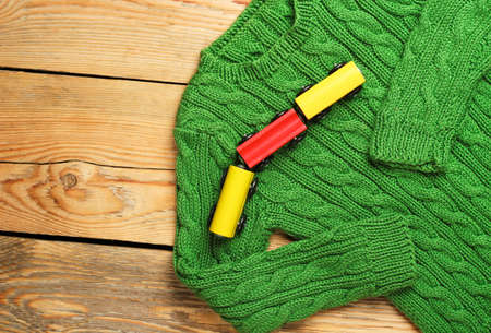 Still life and family concept.Baby boy green sweater with train toy on a wooden table. Selective...