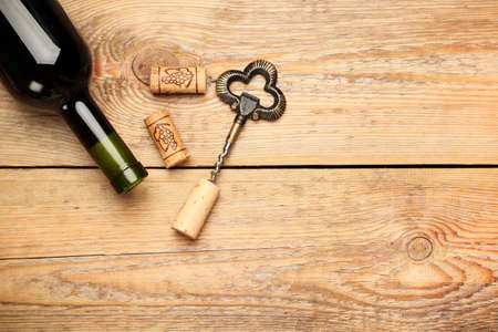Still life, food and drink, holidays concept. Wine corks, bottle and corkscrew on a wooden table. Selective focus, copy space background, top viewの写真素材