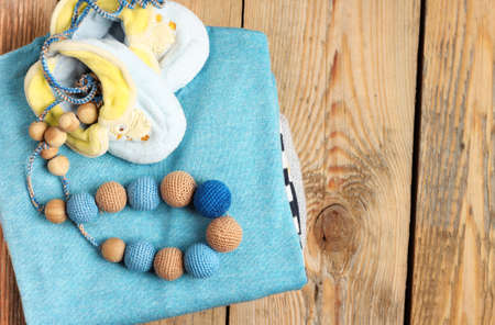 Still life and family concept. Stack of baby boy clothes with toys on a wooden table. Selective focus, top viewの写真素材
