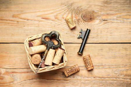 Still life, food and drink, holidays concept. Basket with wine corks and corkscrew on a wooden table. Selective focus, copy space background, top viewの写真素材