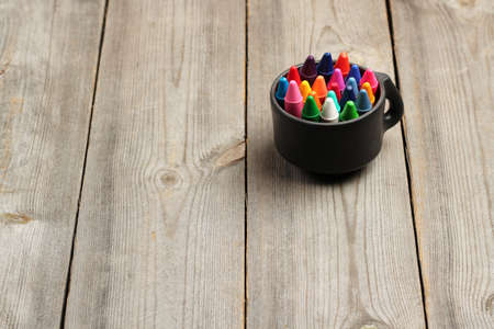 Still life, business, education concept. School, office supplies, crayons (pencils) in a mug on a wooden table. Selective focus, copy space backgroundの写真素材