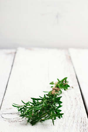 Still life, food and drink, health concept. Fresh herbs (savory) on a wooden table. Selective focus, copy space white background, rustic styleの写真素材