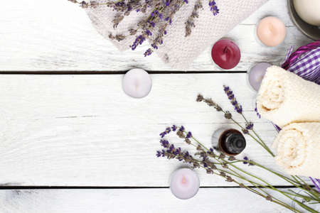 Still life, health and beauty, spa concept. Dry lavender and oil  on a white wooden table. Selective focus, copy space background, top viewの写真素材