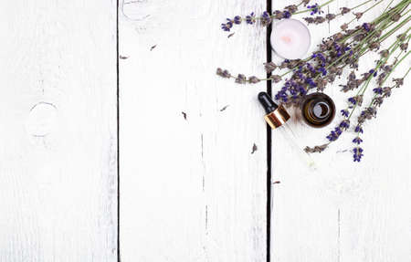 Still life, health and beauty, spa concept. Dry lavender and oil  on a white wooden table. Selective focus, copy space background, top viewの写真素材