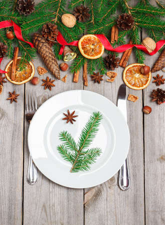 Still life, food and drink, seasonal and holidays concept. Christmas decoration with fir tree, cones, nuts, spices and table setting on a wooden table. Selective focus, copy space background, top viewの写真素材