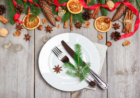 Still life, food and drink, seasonal and holidays concept. Christmas decoration with fir tree, cones, nuts, spices and table setting on a wooden table. Selective focus, copy space background, top viewの写真素材