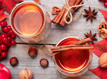 Still life, food and drink, seasonal and holidays concept. Autumn hot beverage in a glass with fruits and spices on a wooden background. Selective focus, top viewの写真素材