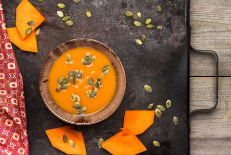 Still life, food and drink, seasonal concept. Fresh orange pumpkin soup in a mug on a rustic wooden table. Selective focus, top viewの写真素材