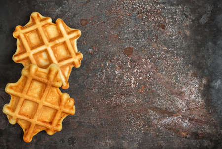 Still life, food and drink, breakfast concept. Homemade belgian waffles on a metal grunge table (rustic style). Selective focus, copy space background, top viewの写真素材