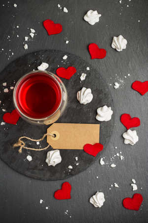 Still life, food and drink, love and holidays concept. Glass of tea, red drink and Valentine Day decoration with red hearts. Selective focus, grunge stone background, top viewの写真素材