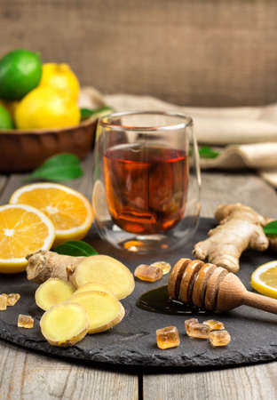 Still life, food and drink, healthcare concept. Ginger tea and ingredients on a black grunge stone table. Selective focusの写真素材
