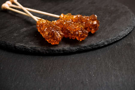 Still life, food and drink concept. Sugar candy sticks on a grunge black table. Selective focus,...