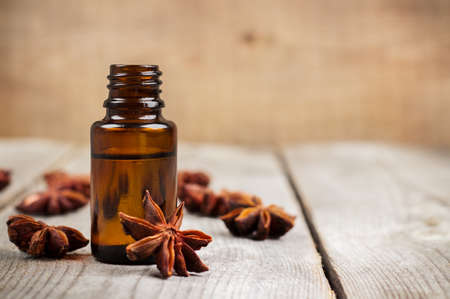 Still life, food and drink, healthcare, beauty concept. Organic anise essential oil on a rustic wooden table. Selective focus, copy space backgroundの写真素材