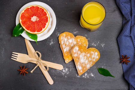 Breakfast with belgian waffles and orange juice on a grunge stone table. Selective focus, top viewの写真素材