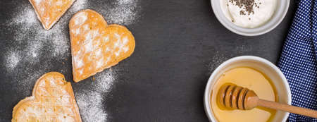 Still life, food and drink concept. Breakfast with belgian waffles, homemade jogurt and honey on a grunge stone table. Selective focus, top viewの写真素材