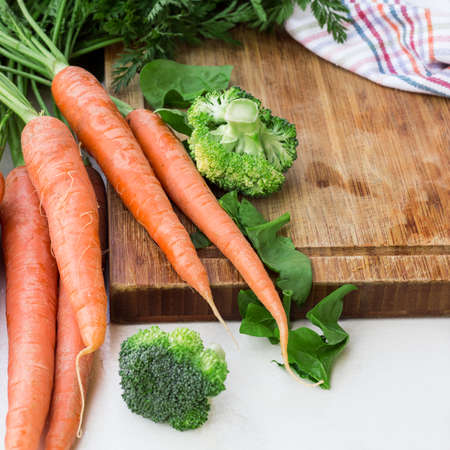 Organic fresh vegetables on a cutting board on a white table. Ingredients for spring soup. Selective focusの写真素材