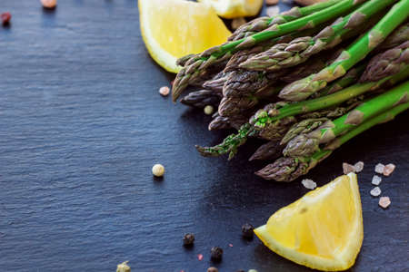 Healthy concept. Bunch of organic fresh asparagus with ingredients for cooking on a grunge stone table. Selective focus, copy space backgroundの写真素材