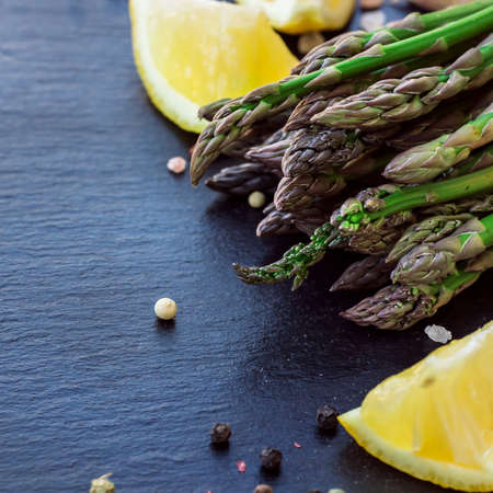Healthy concept. Bunch of organic fresh asparagus with ingredients for cooking on a grunge stone table. Selective focusの写真素材