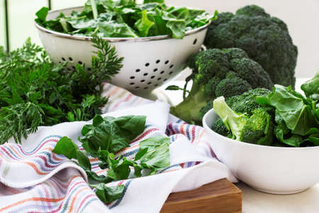 Organic fresh vegetables on a cutting board on a white table. Ingredients for spring soup. Selective focus, outdoor backgroundの写真素材