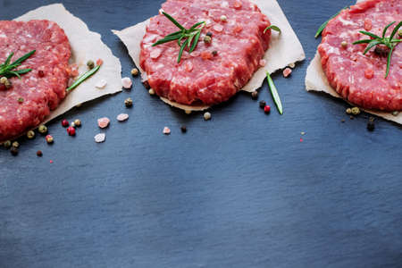 Fresh raw burger cutlets from the farmers market on a black grunge table. Selective focus, copy spaceの写真素材