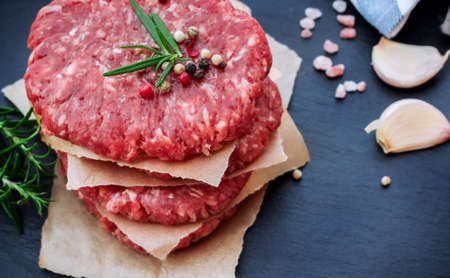 Fresh raw burger cutlets from the farmers market on a black grunge table. Selective focusの写真素材