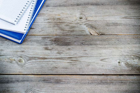 Still life, business, education concept. Stack of notebooks on a rustic wooden table. Selective focus, copy space, school background, top viewの写真素材