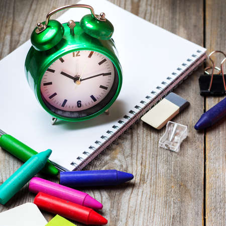 Still life, business, education concept. Assortment of office and school supplies, alarm clock and...