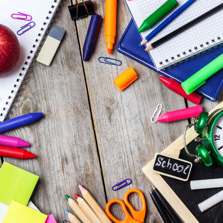 Still life, business, education concept. Assortment of office and school supplies, alarm clock and chalkboard on a rustic wooden table. Selective focus, copy space background, top viewの写真素材