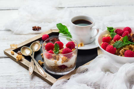 Breakfast, food, still life concept. Coffee muesli granola berries homemade yogurt on a rustic white wooden table. Selective focusの写真素材
