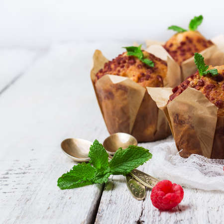 Still life, food and drink, breakfast concept. Fresh homemade muffins with raspberry on a rustic white wooden table. Selective focusの写真素材
