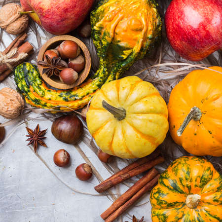 Autumn fall harvest halloween still life composition with pumpkin nuts chestnut spices on rustic table. Selective focus, top view overhead flat layの写真素材