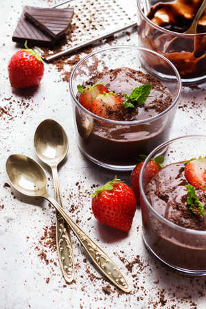 Food and drink, dessert sweet concept. Chocolate mousse with mint and strawberries in glass on rustic table. Selective focusの写真素材