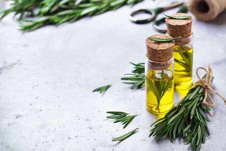 Healthy lifestyle concept. Natural rosemary essential oil on a rusty table for beauty, spa, therapy. Selective focus, copy space backgroundの写真素材