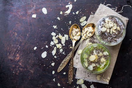 Healthy chia seed pudding with almond milk and fresh fruit topping on a rusty black table. Selective focus, copy space background, top view flat lay overheadの写真素材