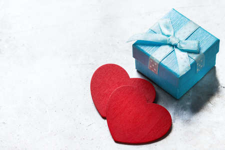 Valentines day concept blue gift box with ribbon and red hearts. Copy space background for your love text message, postcard, greetingの写真素材