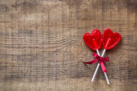 Love and still life concept. Heart shaped candy lollipop for valentines day on a wooden table. Top view flat lay overhead, copy space backgroundの写真素材
