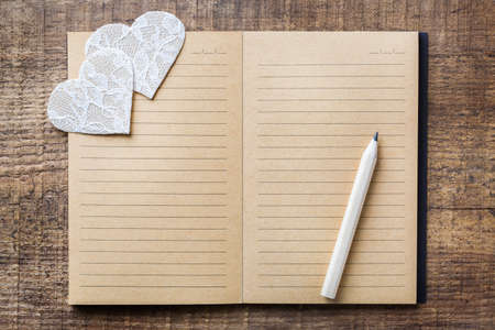 Love and still life concept. Valentines day holiday gift card notebook and pencil crayon on a rustic...