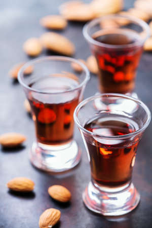 Food and drink, party, alcohol concept. Traditional italian sweet almond liquor amaretto on a grunge black table, digestif beverageの写真素材