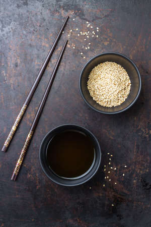 Healthy food and drink concept. Sesame oil and seeds on a chinese japanese table with chop sticks. Top bird view, flat lay overheadの写真素材