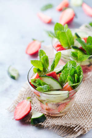 Healthcare, fitness, healthy nutrition concept. Fresh cool cucumber strawberry mint infused water, cocktail, detox drink, lemonade for spring summer daysの写真素材