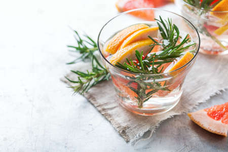Healthcare, fitness, healthy nutrition concept. Fresh cool grapefruit rosemary infused water, cocktail, detox drink, lemonade for spring summer days. Copy space backgroundの写真素材