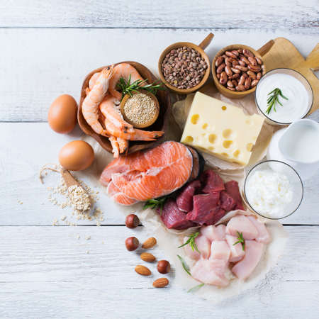 Assortment of healthy protein source and body building food. Meat beef salmon shrimp chicken eggs dairy products milk cheese yogurt beans quinoa nuts oat meal. Top viewの写真素材