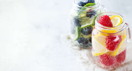 Health care, fitness, healthy nutrition diet concept. Fresh cool lemon lime berries raspberry blueberry infused water, cocktail, detox drink, lemonade for spring summer days. Copy space backgroundの写真素材